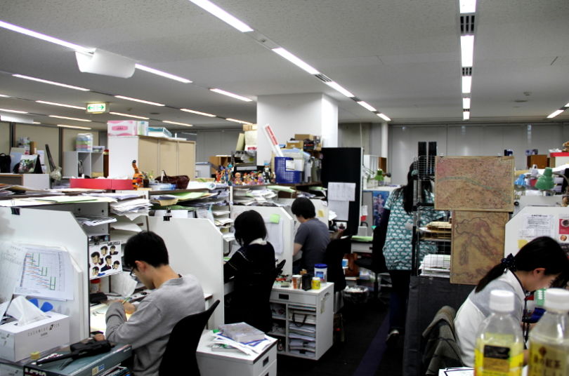 Des animateurs travaillent dans un studio d’animation japonaise, illustrant les conditions de production typiques de l’industrie de l’anime.